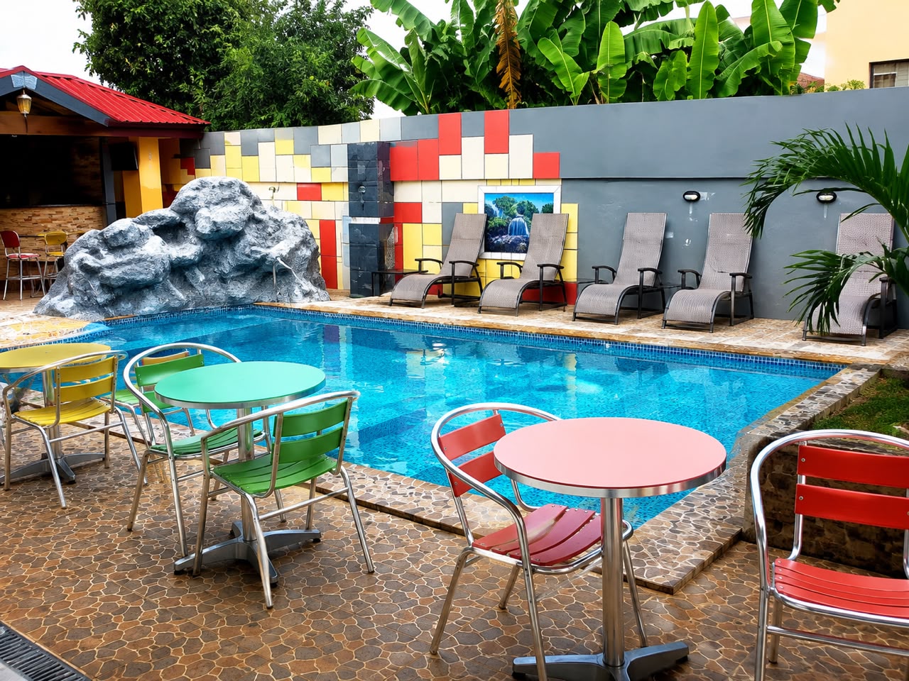 Poolside terrace with colourful seating at Feeb Fiesta Hotel